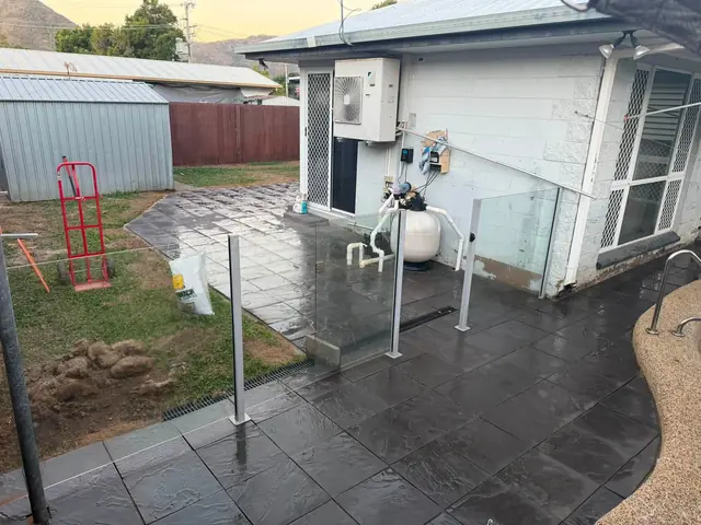 Charcoal slate look paving beside the house and pool fence